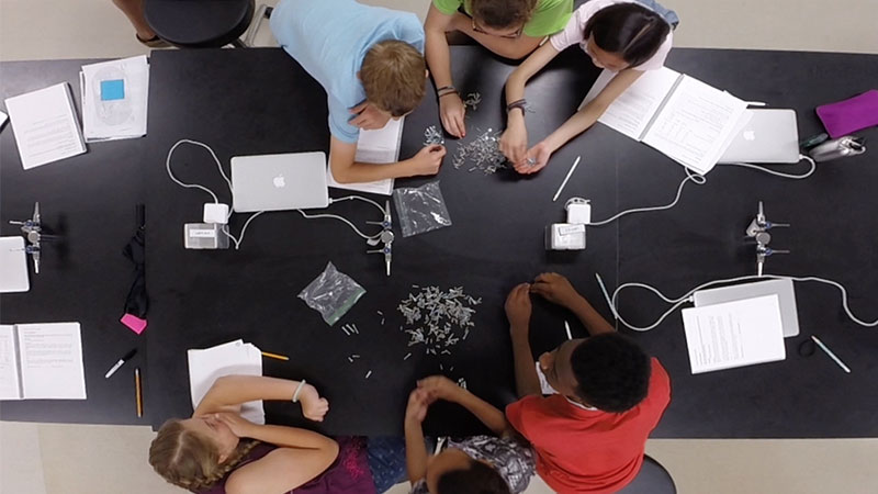 An overhead photograph of a lab table with students
				performing a classifiction exercise with different types of hardware screws.
