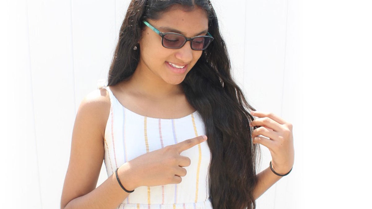 Young woman pointing at her hair to indicate an observable trait.