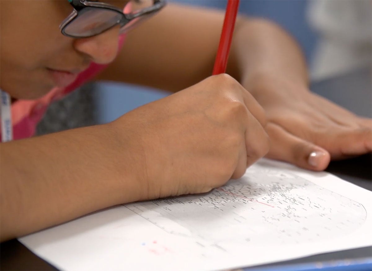 A young woman plots her ancestors journey on a map