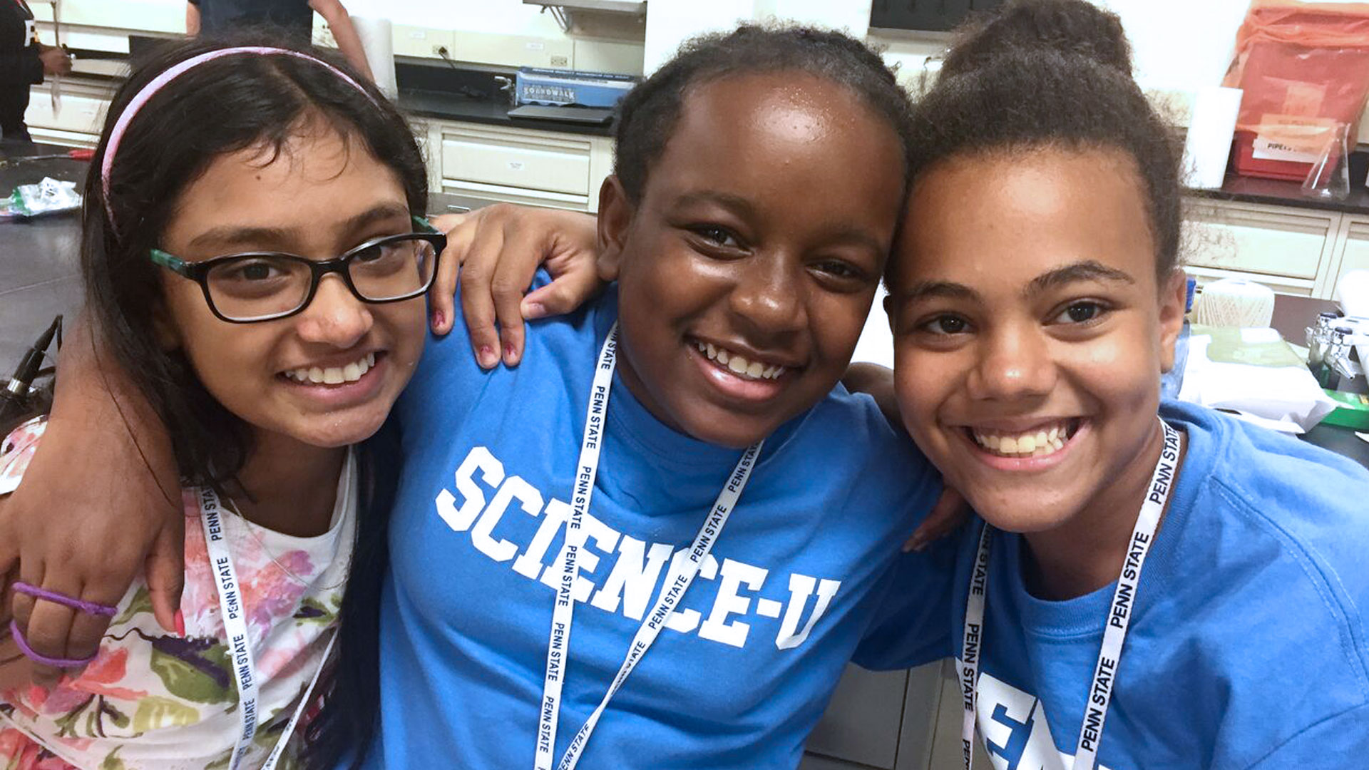 Three students smile during a workshop.